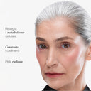 Una donna matura dai capelli grigi, con la pelle liscia e un trucco discreto, posa su uno sfondo bianco. Il testo in italiano mette in evidenza i benefici del Siero Antietà Globale: risveglia il metabolismo cellulare, offre un’azione antirughe per contrastare la perdita di tonicità e dona una pelle levigata e luminosa.