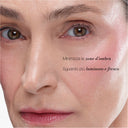 Un primo piano del viso di una donna con un trucco leggero mette in risalto la sua pelle liscia e gli zigomi luminosi. Il testo in italiano sull’immagine invita a ridurre le zone d’ombra e a ottenere un aspetto più luminoso e fresco. Consiglia di utilizzare il Contorno Occhi e Labbra Antietà Globale per attenuare le occhiaie anti-occhiaie e ammorbidire le rughe d’espressione rughe d’espressione, donando un aspetto ancora più radioso.