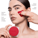 A person applies Makeupstudio - Cipria in Polvere Fissante to their cheek with a red puff while holding a translucent square compact, with text highlighting product benefits in Italian.