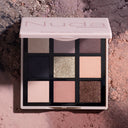 La Nuda Essential - Palette Occhi presenta nove ombretti nude e rosa, con sfumature pigmentate e glitterate, su uno sfondo strutturato che riprende le tonalità della polvere schiacciata della palette.
