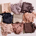 Nove matite schiacciate della Nuda Essential - Palette Occhi, con ombretti nude ricchi di pigmenti nei toni del beige, del rosa, del viola, del navy e dell'oro scintillante, disposti a quadrato su uno sfondo chiaro.