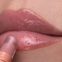 Close-up of glossy lips as Peptize My Lips - Burro Labbra con Peptidi Volumizzante Idratante is applied, giving a smooth, shiny texture and irresistibly plumped look thanks to its peptide-infused formula.