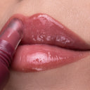 Close-up of glossy, pink lips as Peptize My Lips - Burro Labbra con Peptidi Volumizzante Idratante is applied to the lower lip, leaving them smooth, hydrated, and visibly fuller.