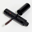 Mascara Ciglione: a black tube printed with "CIGLIONE" and a small red heart, shown open with the wand displaying its bristled brush coated in dark mascara for defined, voluminous lashes with a laminazione effect.