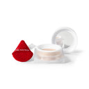 Open jar of Cipria in Polvere Levigante with its lid resting nearby, beside a red triangular makeup puff.