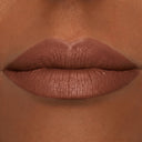 Primo piano di labbra carnose con rossetto opaco di colore marrone medio applicato su una carnagione calda e abbronzata. Le labbra, definite con Plumpfill My Lips - Matita Labbra Effetto Volume per un effetto rimpolpante, sono centrate e leggermente socchiuse, e il rossetto è applicato in modo uniforme.