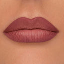 Primo piano delle labbra di una persona che indossa un rossetto malva opaco, con la pelle liscia visibile intorno alla bocca, valorizzata da Plumpfill My Lips - Matita Labbra Effetto Volume per un effetto filler labbra e una tenuta a lunga durata di 24 ore.