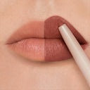 Primo piano delle labbra; il lato sinistro è al naturale, mentre quello destro viene colorato con una tonalità marrone opaca utilizzando Plumpfill My Lips - Matita Labbra Effetto Volume. La matita per labbra applica il colore con precisione sul lato destro, creando un effetto "prima e dopo" di grande impatto che mette in risalto l'effetto filler labbra e promette una tenuta a lunga durata di 24 ore.
