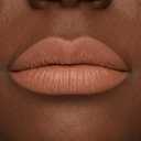 Primo piano delle labbra di una persona dalla pelle liscia e abbronzata, che ne evidenziano la texture naturale e i dettagli. Le labbra sono leggermente chiuse e truccate con un rossetto nude, morbido e opaco, valorizzato dal prodotto “Plumpfill My Lips - Matita Labbra Effetto Volume” per creare un effetto volumizzante.