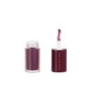 Two tubes of Not So Innocent – Olio Gel Labbra are shown: one open to reveal the wand applicator with product, and one closed. Both feature matte maroon caps. The olio-gel labbra formula delivers an effetto volumizzante while keeping le labbra idratate all day long.