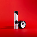 The orgoglioriccio shampoo disciplinante modellante 100ml in a tall cylindrical bottle and a round jar sit on a bright red background, both with minimalist black and white labels featuring a hair silhouette.