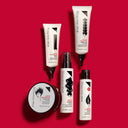 Five bottles and tubes of RICCIOFLUIDO - POZIONE ATTIVARICCI hair care products arranged on a red background.