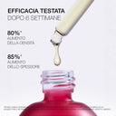 Goccia di siero trasparente che esce da contagocce sopra flacone di vetro chiaro.