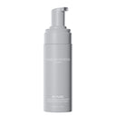 Un flacone grigio con erogatore, recante l'etichetta “Diego dalla Palma Milano Mousse Detergente Detossinante, 150 ml”. Questa mousse detergente anti-inquinamento per il viso presenta un testo e un design semplici e minimalisti su sfondo bianco.