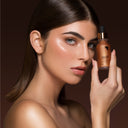 modella mora con in mano il pack di un autoabbronzante per il viso